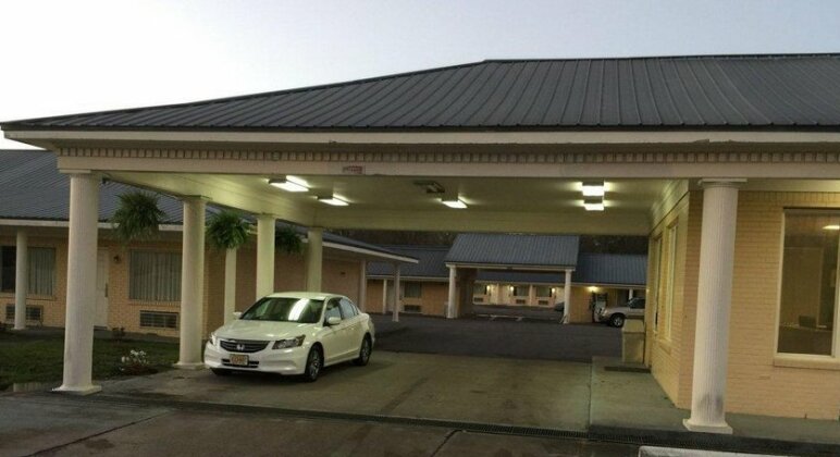 Greenwood Inn covered entrance illuminated at dusk